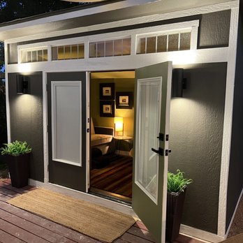 A well-lit modern studio with open double doors, featuring a cozy interior decorated with framed art and warm lighting, designed by Cypress Southern Homes in Tomball.